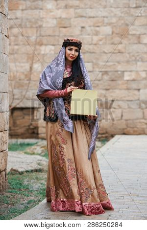 Young Azeri Woman In Traditional Azerbaijani Dress, With Present Box In Her Hands