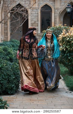 Beautiful Azeri Women In Traditional Azerbaijani Dress Running By The Wooden Door