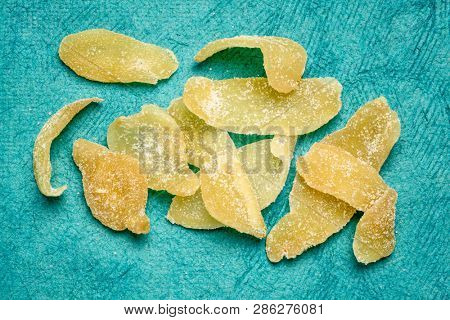 crystallized ginger slices against tuquoise bark paper