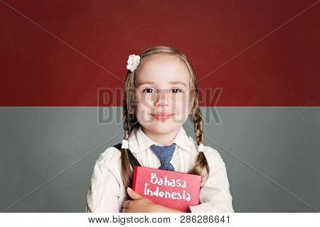 Indonesia Concept With Kid Little Girl Student With Red Book Against The Indonesian Flag Background.