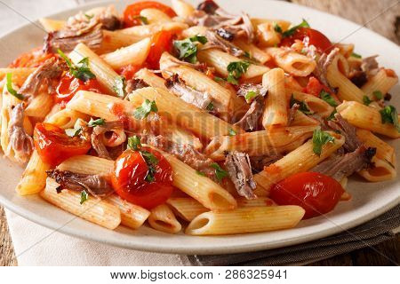 Spicy Tasty Penne Pasta With Grilled Pulled Pork, Cheese, Tomato Sauce And Herbs Close-up On The Tab