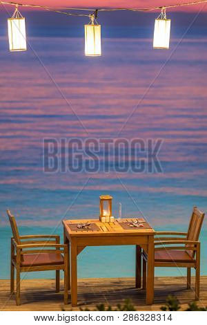 Romantic sunset on the shore of a tropical island, Koh Chang, Thailand. Outdoor ?afe on the beach.