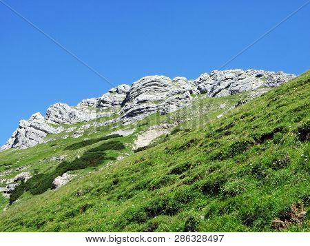 Mountain Hikers On The Alpine Peak Of Margelchopf And In The Alviergruppe Mountain Range - Canton Of