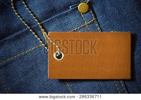 Leather Label Of Product Price And Stainless Steel Ball Chain On Denim Clothing. The Concept Of Fash