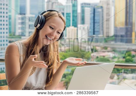 Young Woman Teaches A Foreign Language Or Learns A Foreign Language On The Internet On Her Balcony A