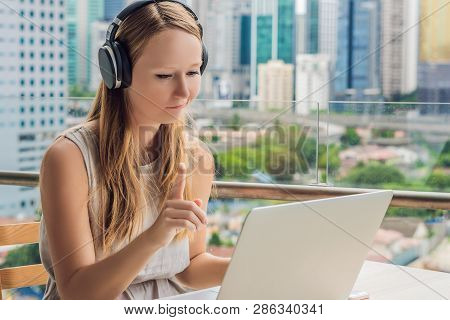 Young Woman Teaches A Foreign Language Or Learns A Foreign Language On The Internet On Her Balcony A