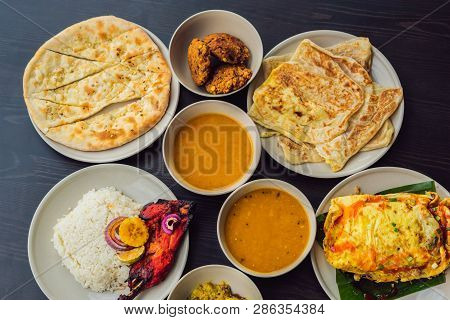 Assorted Indian Food On Dark Wooden Background. Dishes And Appetizers Of Indian Cuisine. Curry, Butt