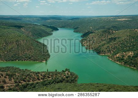Tagus River Running Through A Hilly Valley With Trees And House