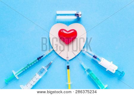 Volumetric Heart Shape With A Set Of Different Syringes On A Blue Background. The Concept Of Support