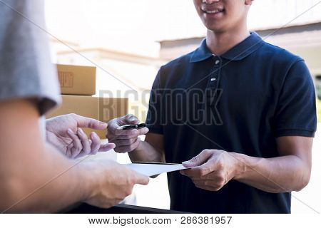 Delivery Mail Man Giving Parcel Box To Recipient And Signature Form, Young Owner Signing Receipt Of 