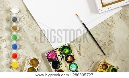 Flatlay With Bright Water Colour Paints In Small Round Containers And Bottles And Palettes As Frame,