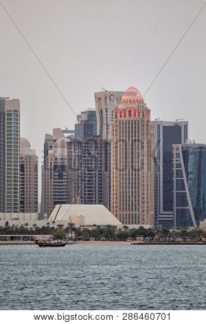 DOHA, QATAR - January 30, 2017: View across Doha Bay. to the hotels and businesses of the high rise Dafna district, lit up as night approaches