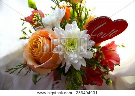 Valentine's Day Concept. Beautiful Bouquet Of Flowers With Heart Shape Sign