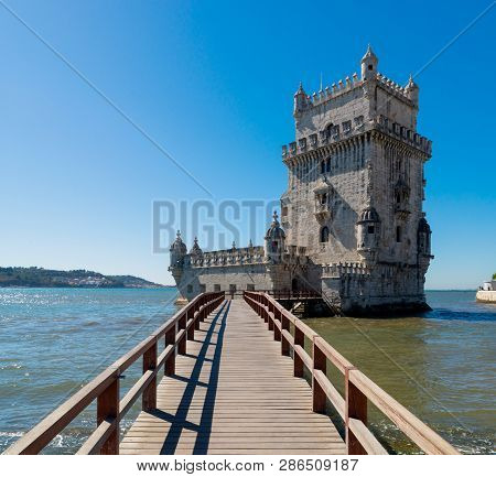 Scenic Belem Tower And Wooden Bridge Miroring With Low Tides On Tagus River. Torre De Belem Is Unesc