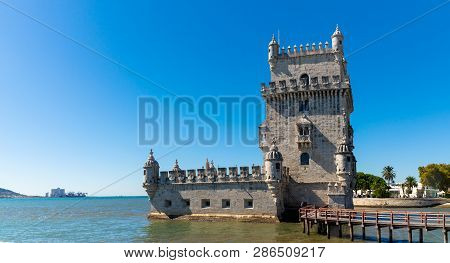 Scenic Belem Tower And Wooden Bridge Miroring With Low Tides On Tagus River. Torre De Belem Is Unesc
