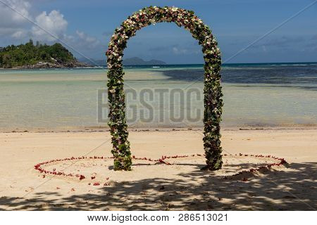 Romantic Wedding On The Beach At Mahe Island, Seychelles. Wedding Arche Decorated With Tropical Flow