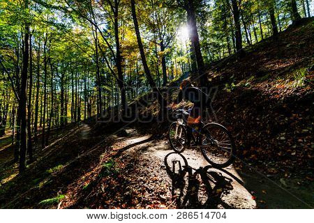 Cycling woman riding on bike in summer mountains forest landscape. Woman cycling MTB flow trail track. Outdoor sport activity.