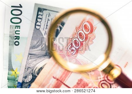 Five Thousand Russian Rubles  Under A Magnifying Glass On The Bacdrop Euro And Usa Dollar. Сoncept O