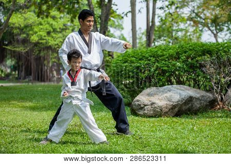 Father Coach Is Training His Son Boy Taekwondo In Green Park .children Kid And Teacher Master Traine