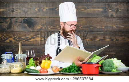 Book Recipes. According To Recipe. Man Bearded Chef Cooking Food. Guy Read Book Recipes. Culinary Ar
