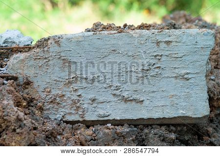 Closeup Broken Concrete Structure With Reinforcement Steel Lay On The Soil Ground