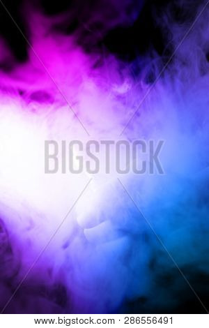 Male Hand Holds Vape In Thick Vape Fog Or Smoke. Vape Clouds Around Hand With Vape On Black Backgrou