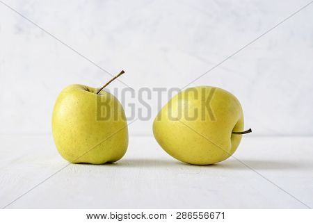 Two Ugly Misshapen Golden Fresh Apples Viewed Side By Side Low Angle On White