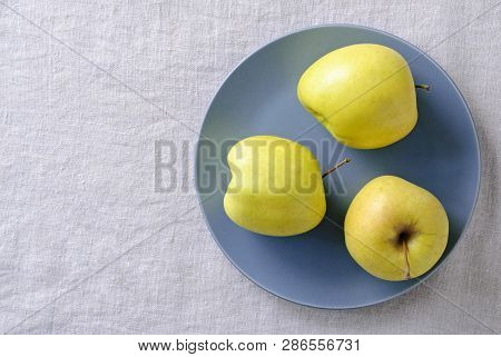Ugly Fresh Food Concept With Fresh Misshapen Golden Apples On A Blue Plate In A Concept Of Aesthetic