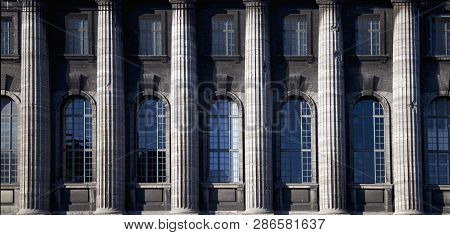 Architectural Background Of Facede Of Antique Building With Windows And Column.