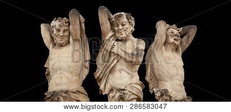 Antique Statue Of Satyrs. They Have The Hindquarters, Legs, And Horns Of A Goat. Iswolated On Black 