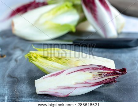 Group Of Fresh Green Belgian Endive Or Chicory And Red Radicchio Vegetables, Also Known As Witlof Sa