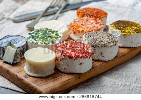 Assortment Of French Fresh White Soft Goat Cheeses With Different Tastes Topping Made With Herbs, Pa