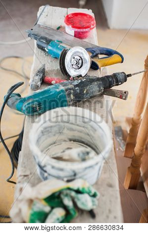 Working Gloves. Do Makeovers. Putty Knife Lying On The Bucket. Tools For Construction And Repair. Se