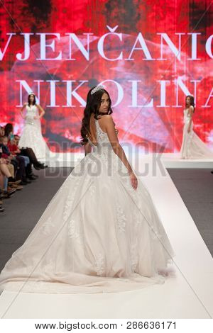 ZAGREB, CROATIA - FEBRUARY 02, 2019: Fashion model in a wedding dress walking down the runway at the Wedding fair