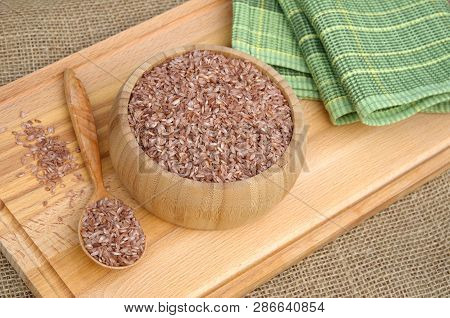 Uzbek Devzira, The Red Rice For Cooking Pilaf On A Wooden Board