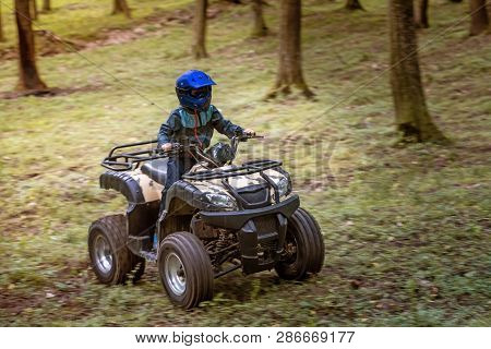 The Boy Is Traveling On An Atv.