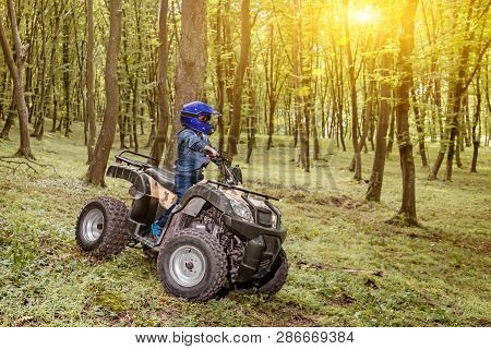 The Boy Is Traveling On An Atv.