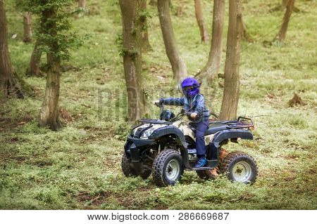 The Boy Is Traveling On An Atv.