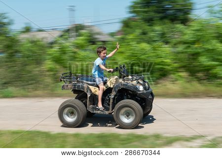 The Boy Is Traveling On An Atv.