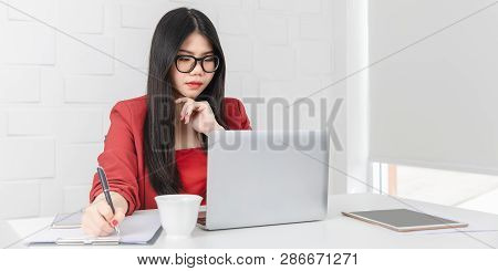 Young Attractive Asian Businesswoman, Long Black Hair, Wearing Glasses, Smiling, Writing Note On Not
