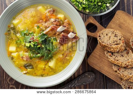 Delicious Yellow Split Peas Soup With Smoked Pork Ribs  On A Wooden Table. Top View