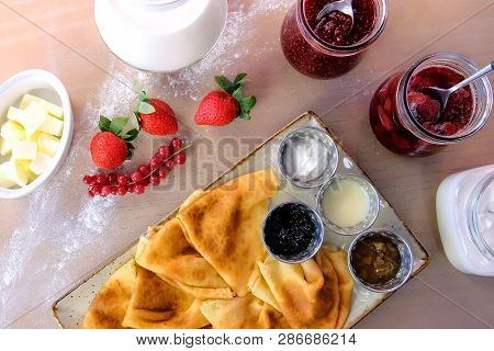 Traditional Russian Pancakes, Blini. Served With Jams, Sour Cream, Milk And Strawberry On The Plate.