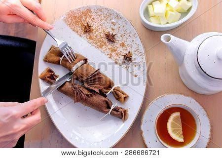 Woman, Is Eating Chocolate Russian Pancakes, Blini With Curd Filling On The Plate. Hands Close-up. S