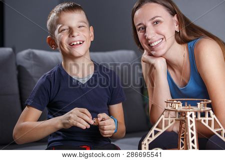 Young Boy Assembling Constructor With His Mother.