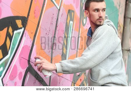 A Young Graffiti Artist Looks Around While Drawing. Vandal Tries