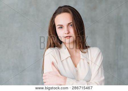Woman Facial Expression. Young Beautiful Female Looking Wearily Feeling Cold. Copy Space On Grey Bac