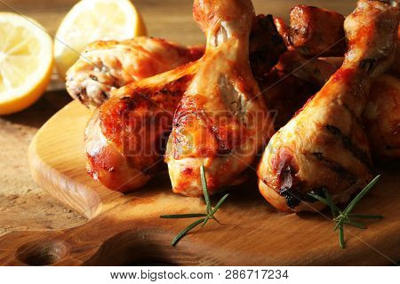 Grilled Chicken Legs On Cutting Board. Rustic Background