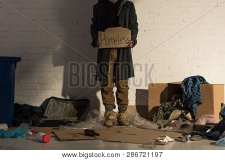 Cropped View Of Houseless Man Holding Piece Of Cardboard With Homeless Handwritten Text