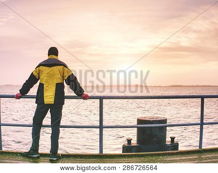 Man Thinking. Tourist In Warm Clothes On Sea Mole At Handrail. Autumn Misty Day. Tourist On Pier In 