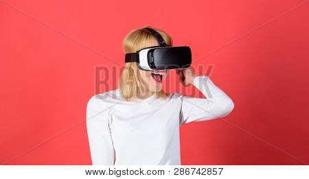 Portrait Of Woman In A White Blouse With Virtual Reality Glasses On Head Isolated On Red Background.